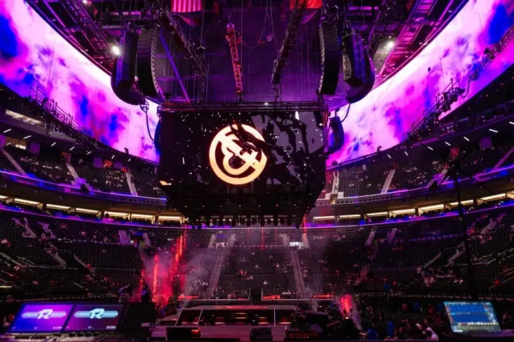 An arena rig lit purple before doors, seen from the floor.
