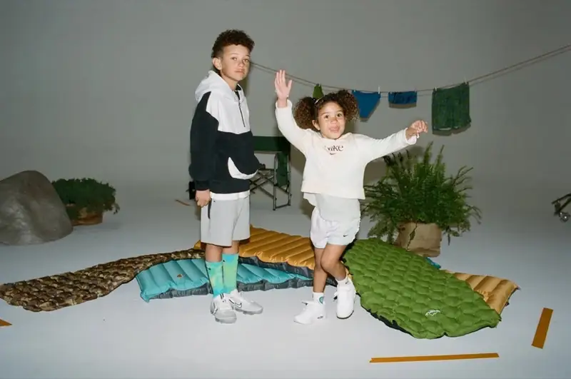 Two child models on a styled cyc wall during a Nike commercial shoot.